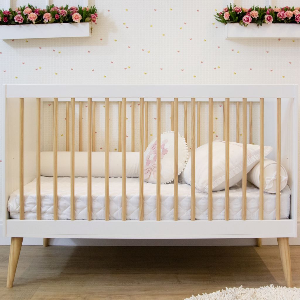 Berço Branco com Detalhes em Madeira em um Quarto com Flores