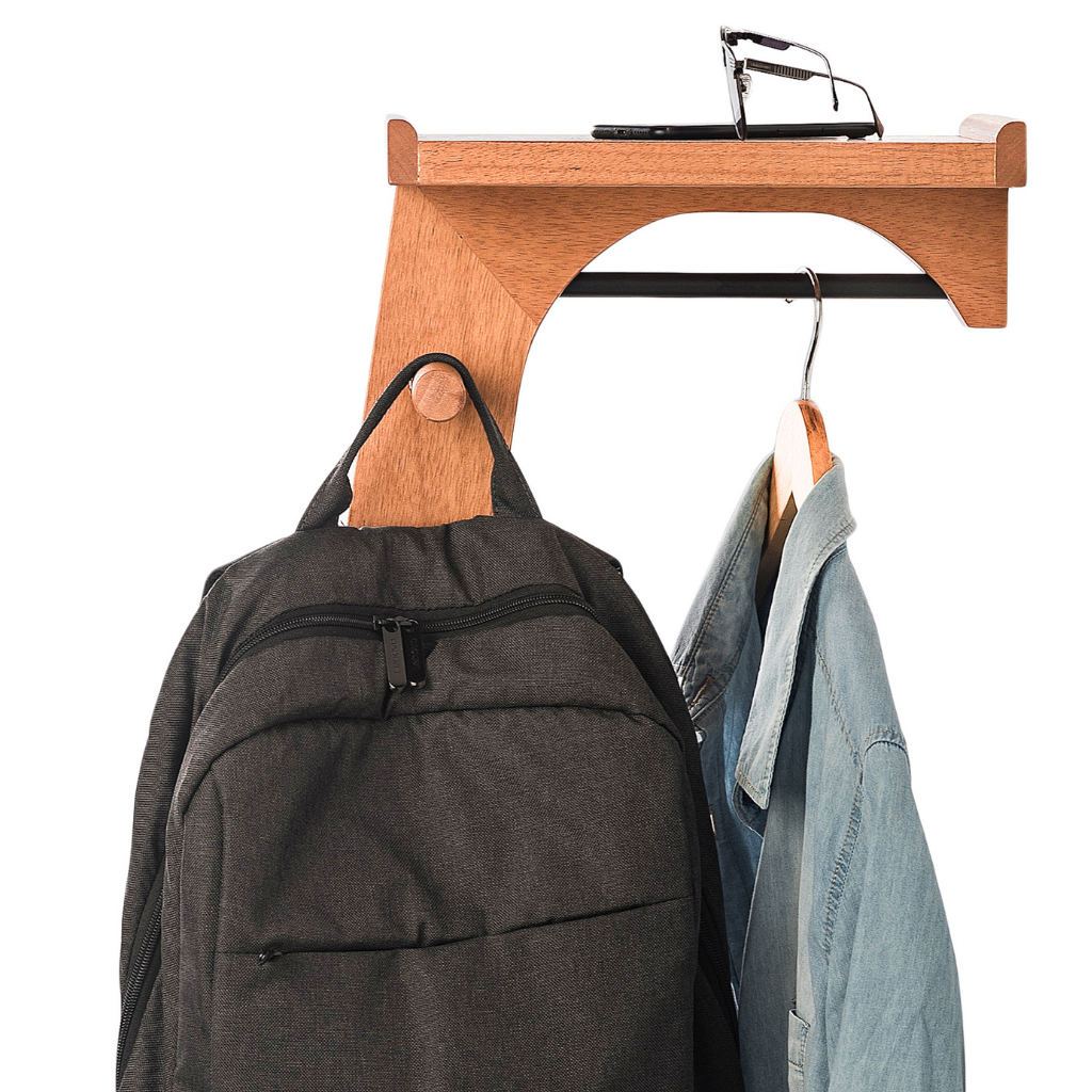 Foto mostrando mais detalhadamente como fica de lado o cabideiro. Mostrando o porta mochilas/bolsas e o cabide. Com objetos para demonstrar a utilidade